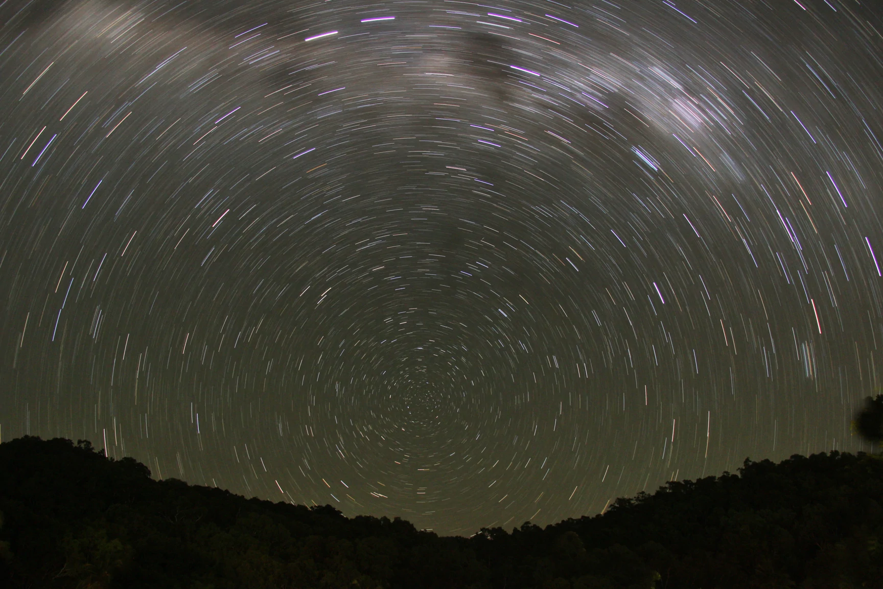 Long exposure picture of stars. The trajectories of each star is visible, creating many circular lines.